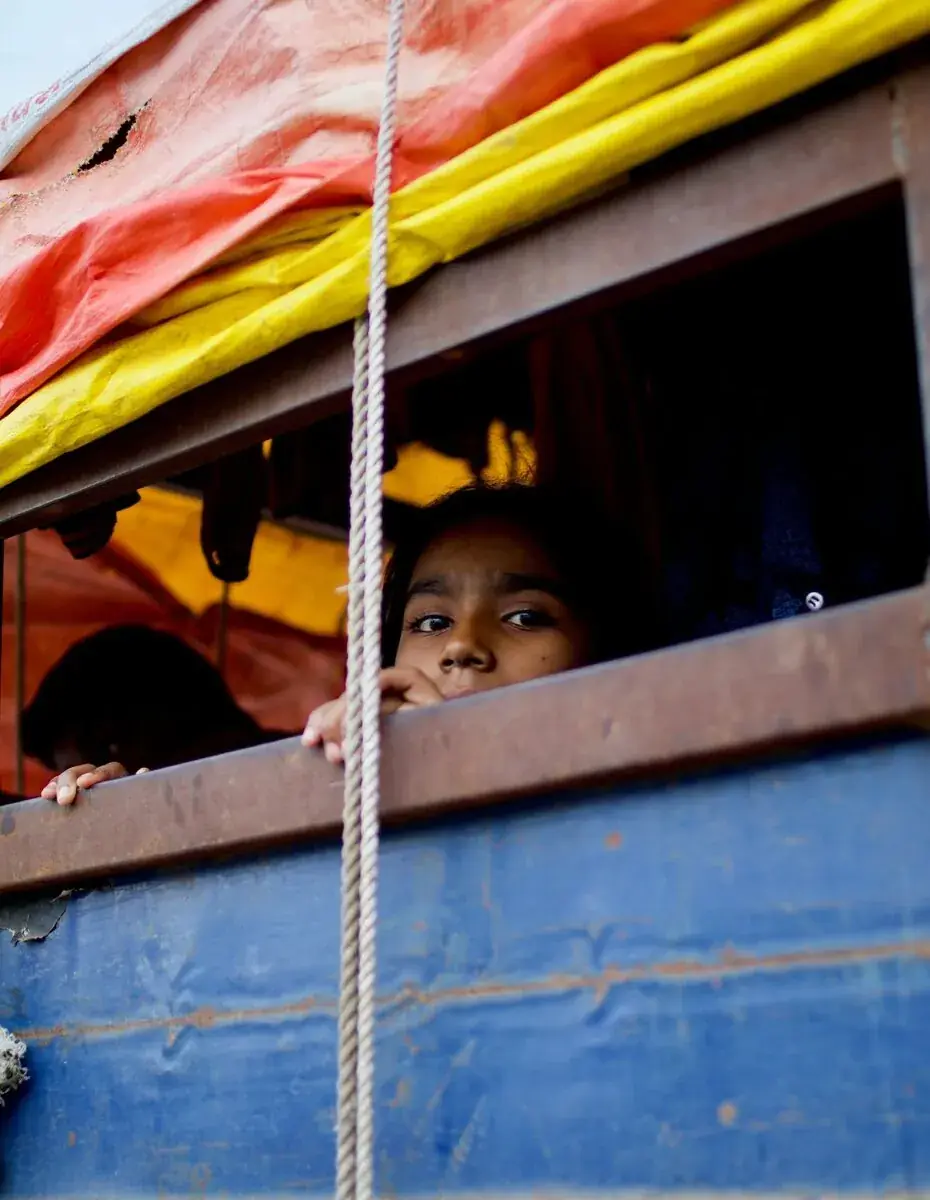 A child smiling from a bus window