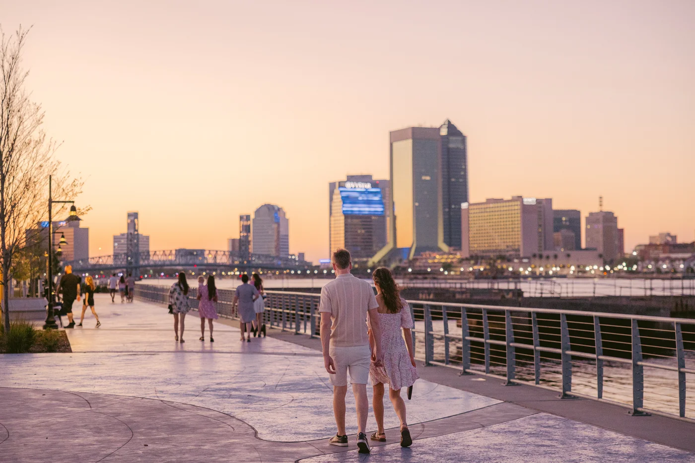 People walking along the Jacksonville riverfront at sunset