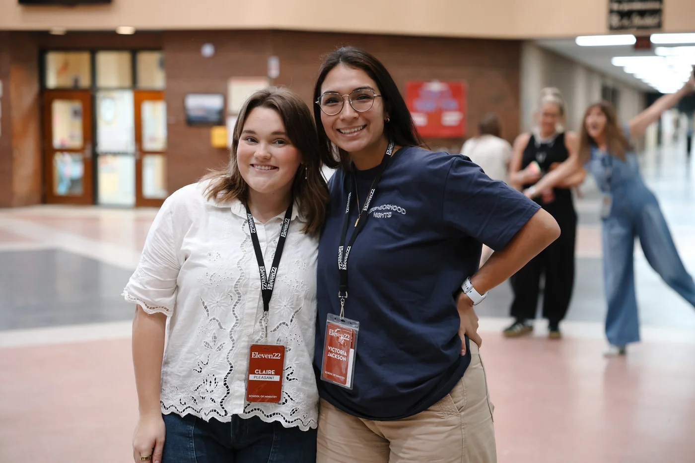 Two School of Ministry participants smiling together in a hallway